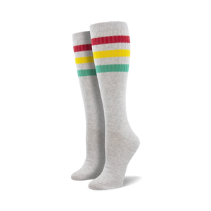 Pair of light blue knee-high socks with a vibrant rainbow striped cuff against a white background.