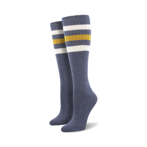 Pair of light blue knee-high socks with a vibrant rainbow striped cuff against a white background.