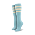 Pair of light blue knee-high socks with a vibrant rainbow striped cuff against a white background.