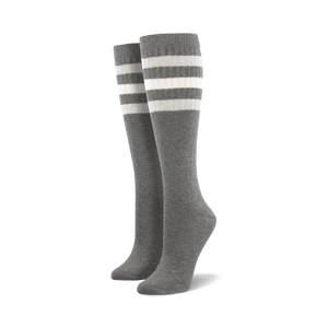Pair of light blue knee-high socks with a vibrant rainbow striped cuff against a white background.