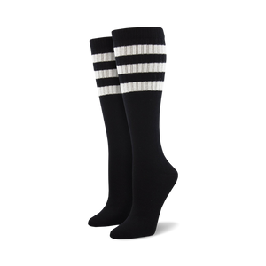 Pair of light blue knee-high socks with a vibrant rainbow striped cuff against a white background.