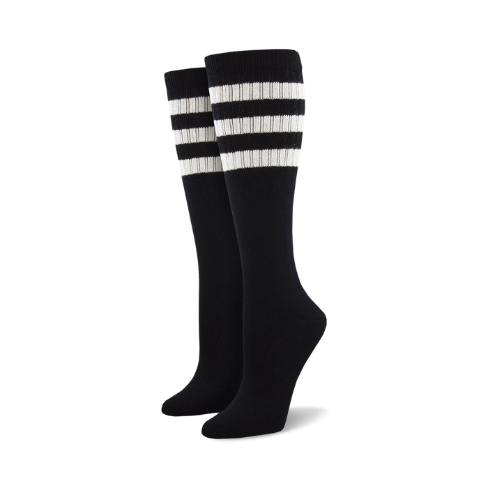 Pair of light blue knee-high socks with a vibrant rainbow striped cuff against a white background.