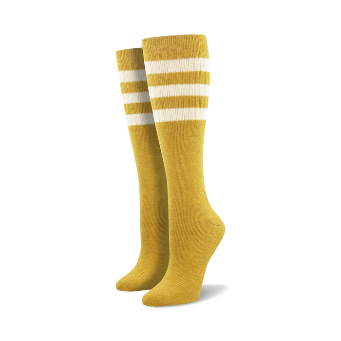 Pair of light blue knee-high socks with a vibrant rainbow striped cuff against a white background.