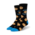 Lifestyle shot of Tough Cookie socks on a person's feet; the socks are black with blue cuffs and chocolate chip cookie designs.