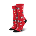 Pair of crew socks; red background with black and white cows and white flowers.  Black heel and toe.