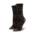 Crew socks in black with a repeating burnt orange caffeine molecule pattern.  Grey heel and toe. 