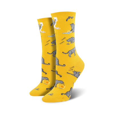 gray cat crew socks for women with playful cat designs on a yellow background. featuring cats licking themselves, playing with yarn, and drinking from bowls.   