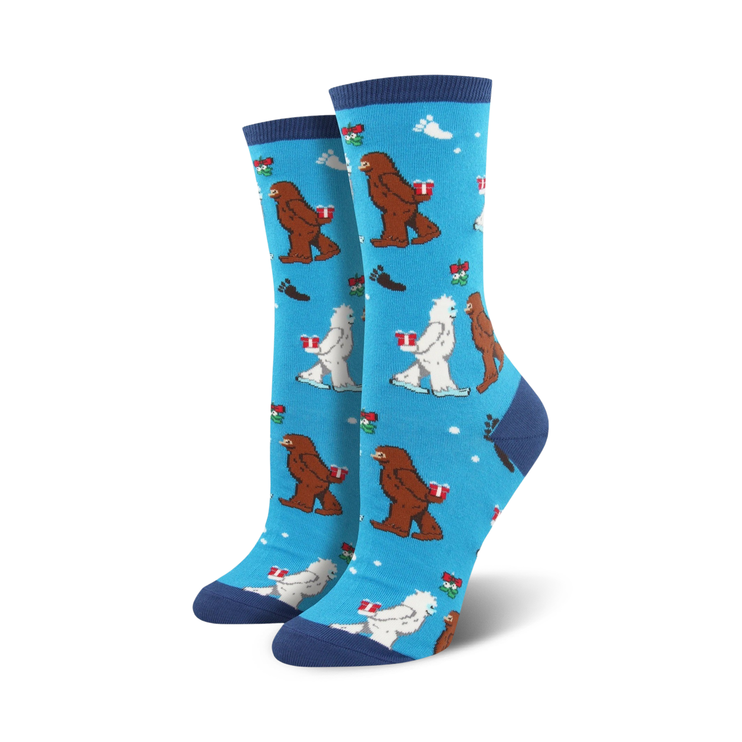Crew socks in blue, green, and red featuring Bigfoot and Yeti characters carrying gifts on a snowflake background.