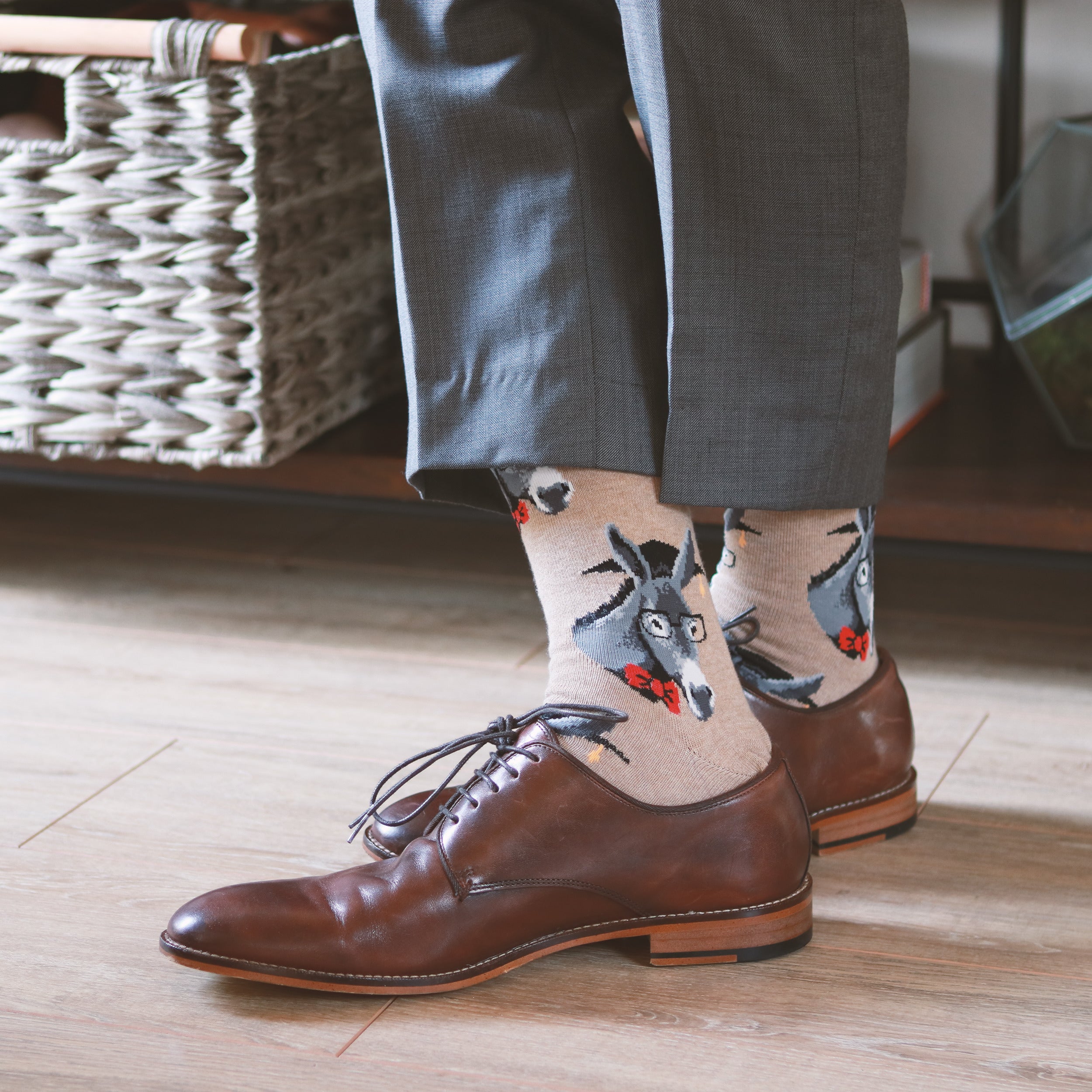 Close-up lifestyle shot: A person wearing tan donkey socks with brown leather shoes. [lf]