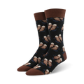 Pair of crew socks; black background with repeating pattern of brown otters swimming; brown cuff.