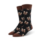 Pair of crew socks; black background with repeating pattern of brown otters swimming; brown cuff.