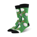 Pair of crew socks with a golf theme. Green background features white golf balls and red and blue tees. Black cuff and sole.