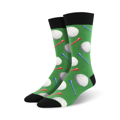 Pair of crew socks with a golf theme. Green background features white golf balls and red and blue tees. Black cuff and sole.