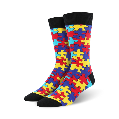 Pair of crew socks with a puzzle-piece design. The socks are predominantly red, yellow, blue, and teal.
