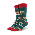 Pair of crew socks, green with brown reindeer wearing red harnesses, red cuffs, snowflakes on a dark teal background.