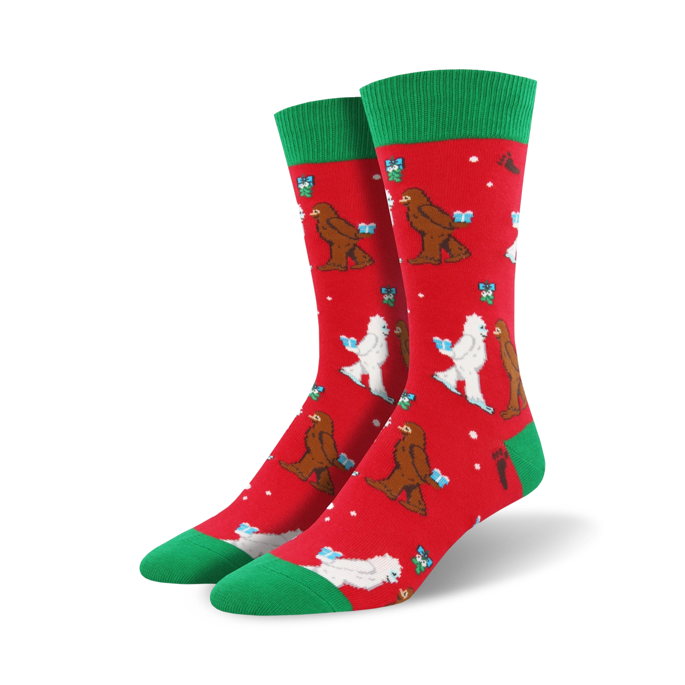 Crew socks in red with green cuffs.  The design features Bigfoot and Yeti figures exchanging gifts in a playful Christmas scene.
