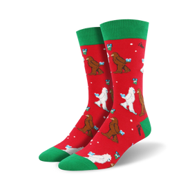 crew length christmas socks in red with cartoonish white abominable snowmen wearing santa hats and carrying gifts on a red background with green snowflakes and a green top.   