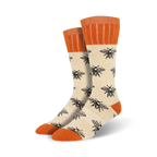 Pair of cream crew socks with a black bee pattern and orange cuffs. 