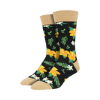 Pair of black crew socks with a bold yellow hibiscus and white flower pattern, tan cuff.
