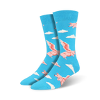 Pair of blue crew socks featuring a fun pattern of pink winged pigs flying above white clouds.