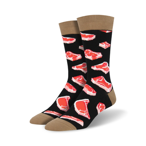 Pair of black crew socks with a repeating pattern of red steak images. Tan cuff detail.