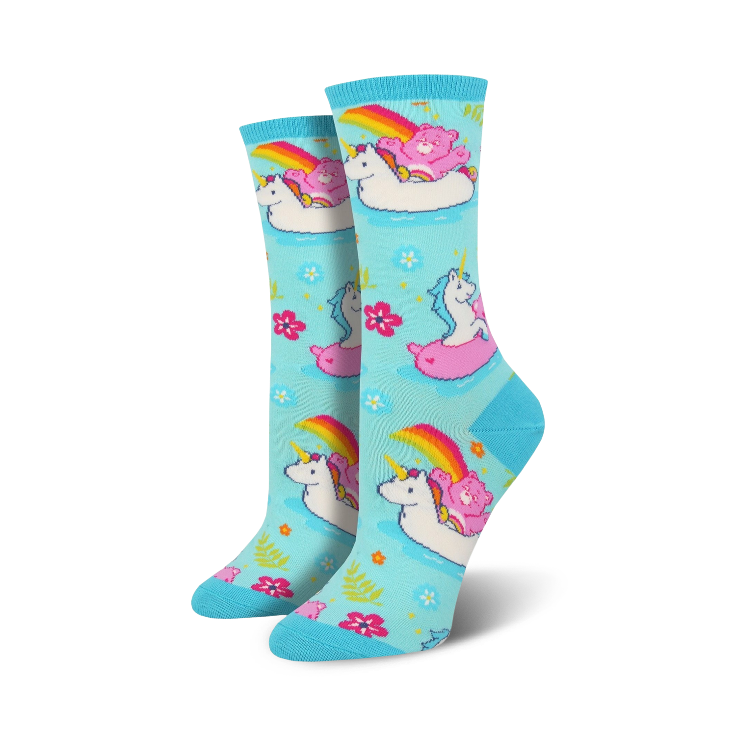 Crew socks in light blue featuring unicorns, Care Bears, and rainbows on inflatable swans. Pink, white, and rainbow accents on a pastel background.