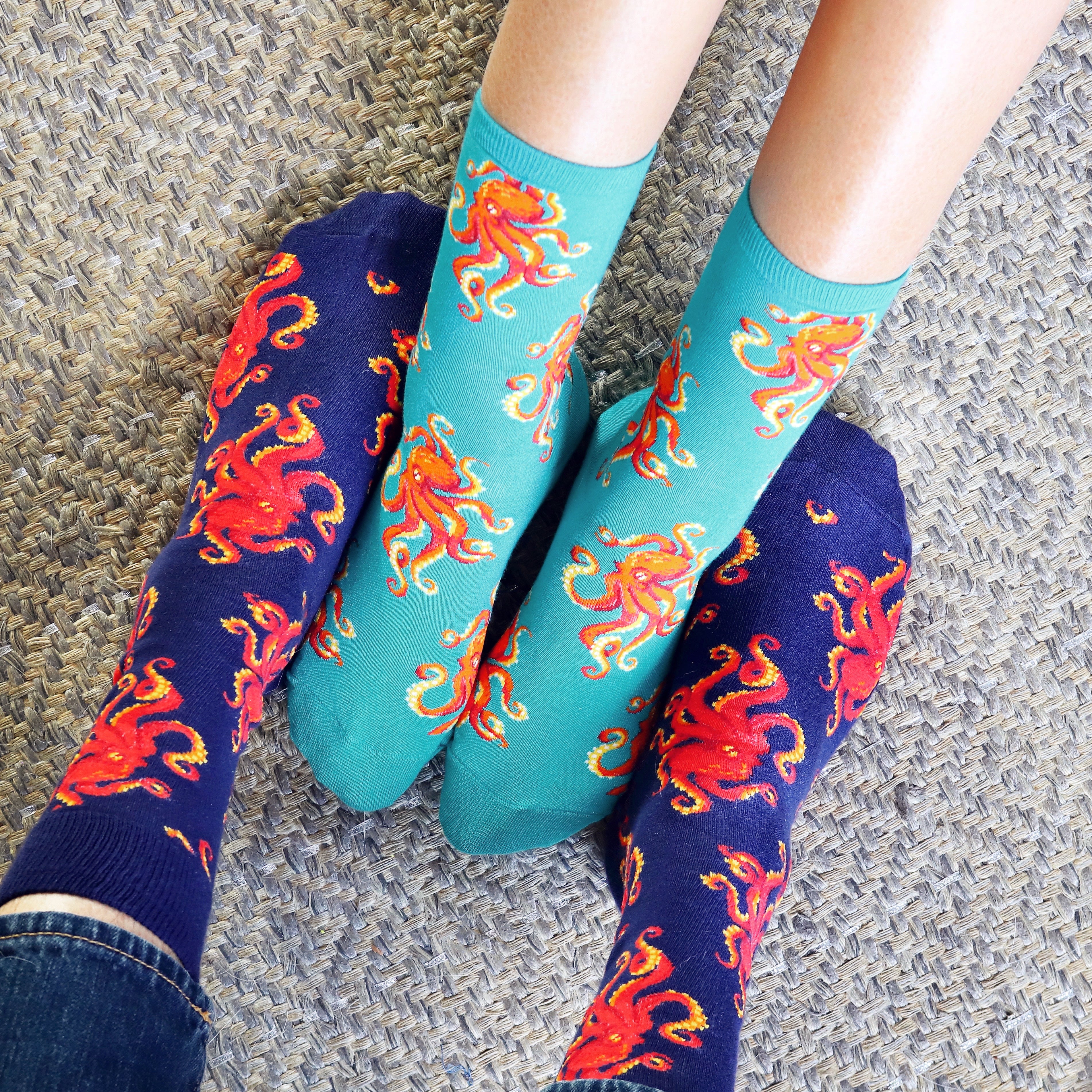 Two people's feet in teal and black octopus socks. [lf]