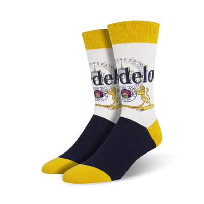 white crew socks with blue toe and heel and yellow top and bottom. pattern of modelo logo with text "modelo especial" and "cerveza fina".   