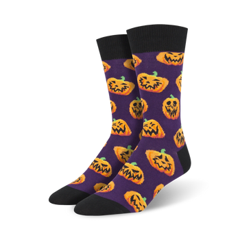 mens purple halloween-themed crew socks feature an all-over pattern of goofy jack-o'-lanterns.  