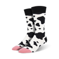 Pair of crew socks with a black and white cow print design.  Pink accents at the toes. Fun and quirky style.