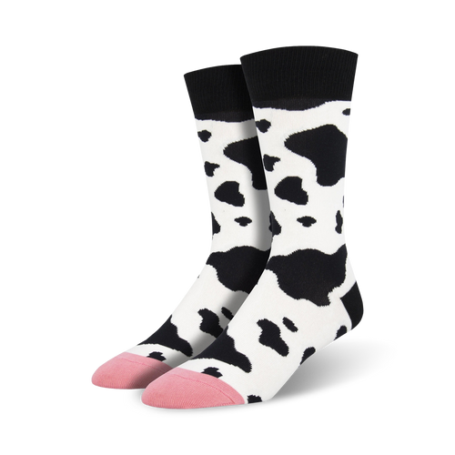 Pair of crew socks with a black and white cow print design.  Pink accents at the toes. Fun and quirky style.