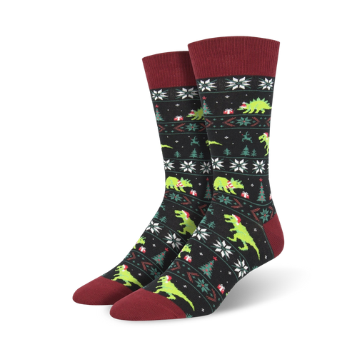 Pair of crew socks, black and green, featuring a Christmas-themed pattern with dinosaurs wearing Santa hats.