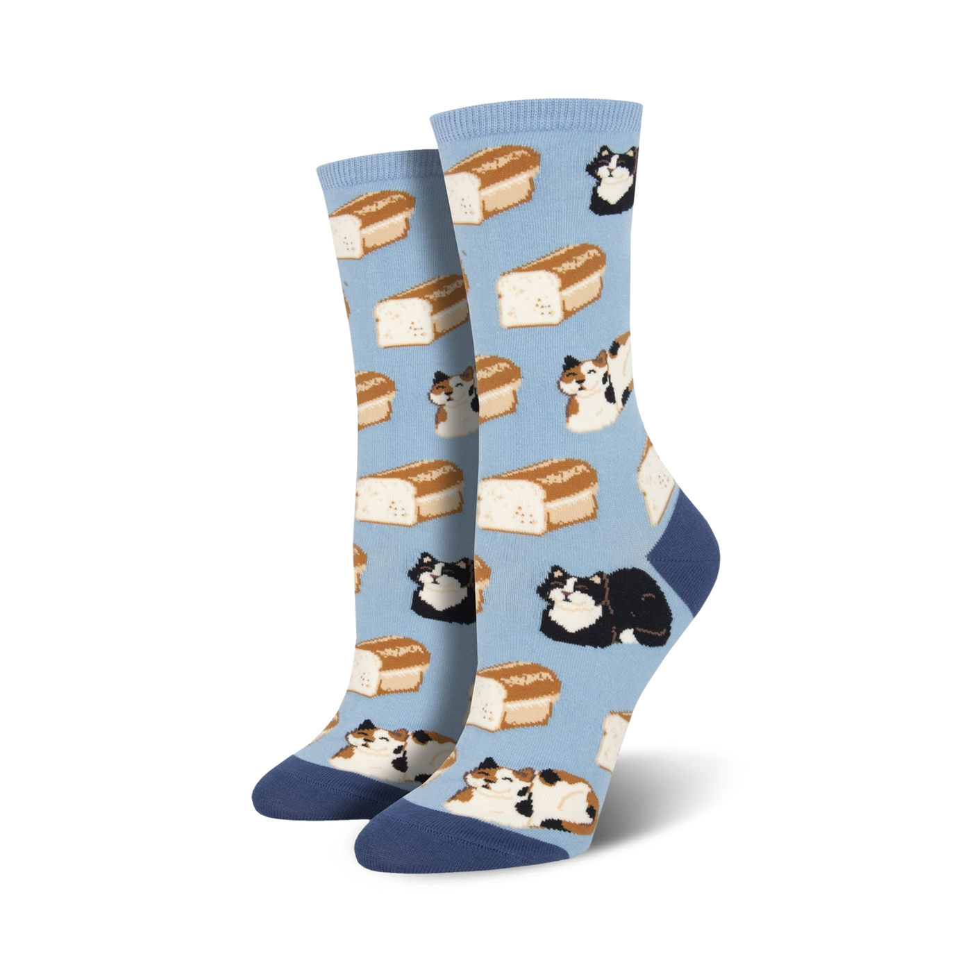 A pair of women's crew socks in light blue. The socks feature a pattern of calico and black cats lounging on loaves of bread.