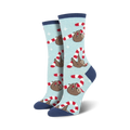 Lifestyle flat lay photo showing a pair of light blue Merry Slothmas socks surrounded by candy canes shaped into hearts.