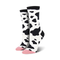 Pair of women's crew socks in a black and white cow print.  The toes are a light pink color.