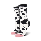 Pair of women's crew socks in a black and white cow print.  The toes are a light pink color.