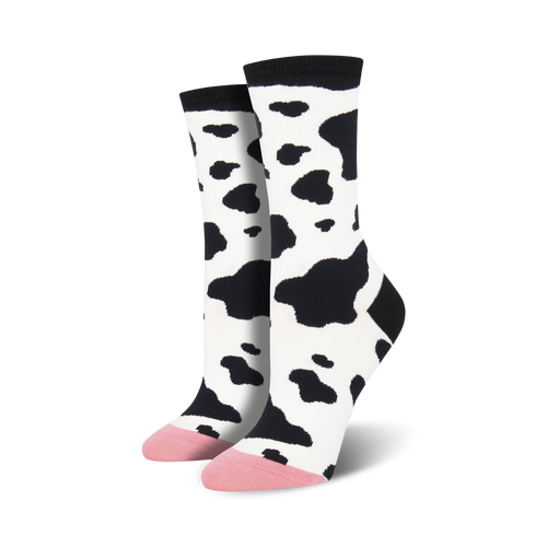 Pair of women's crew socks in a black and white cow print.  The toes are a light pink color.