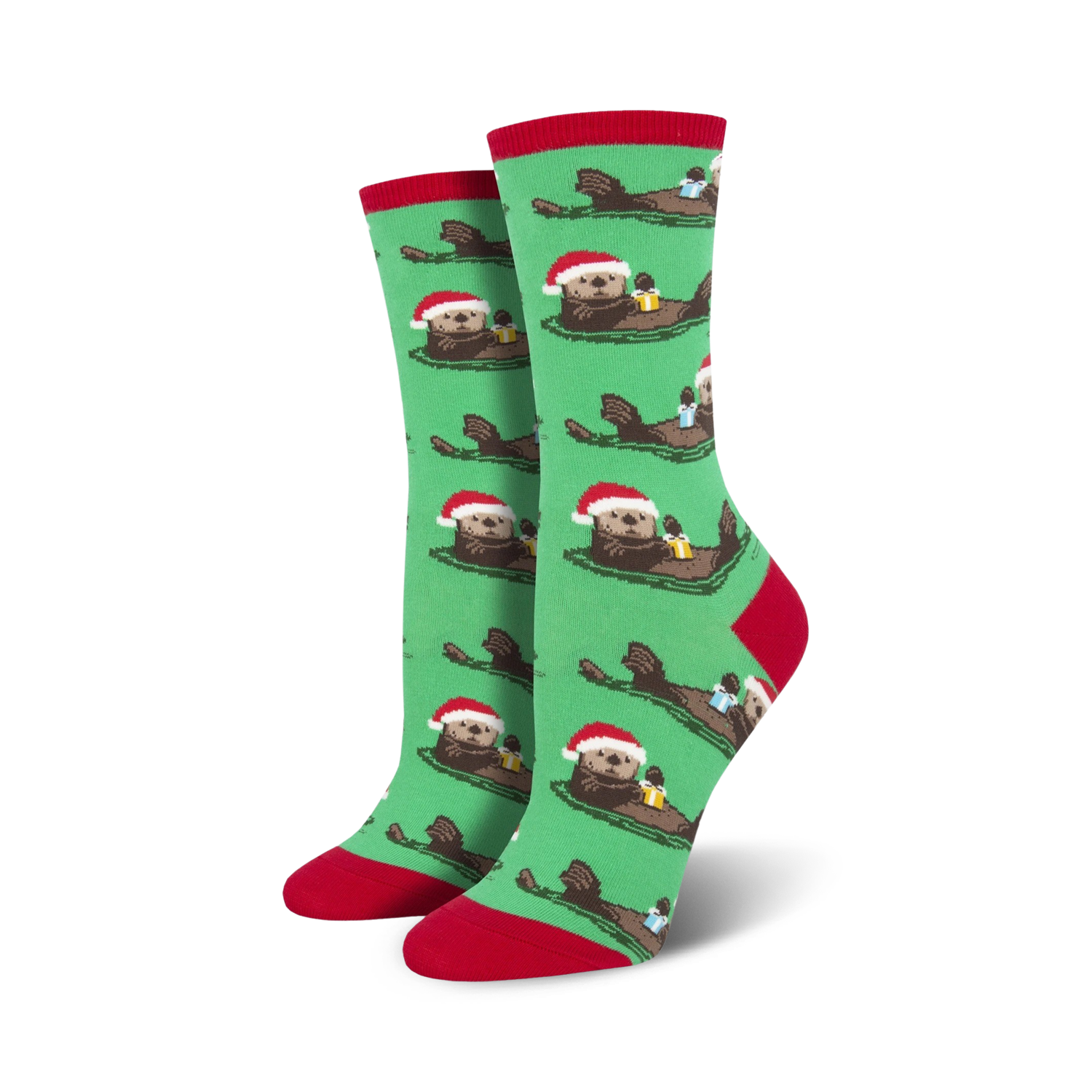 Pair of women's crew socks. Green background with repeating pattern of otters wearing Santa hats and holding gifts. Red and teal accents.