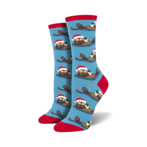 bright blue women's crew socks featuring cartoon otters in santa hats swimming in a light blue sea with red sock tops. perfect for christmas.  