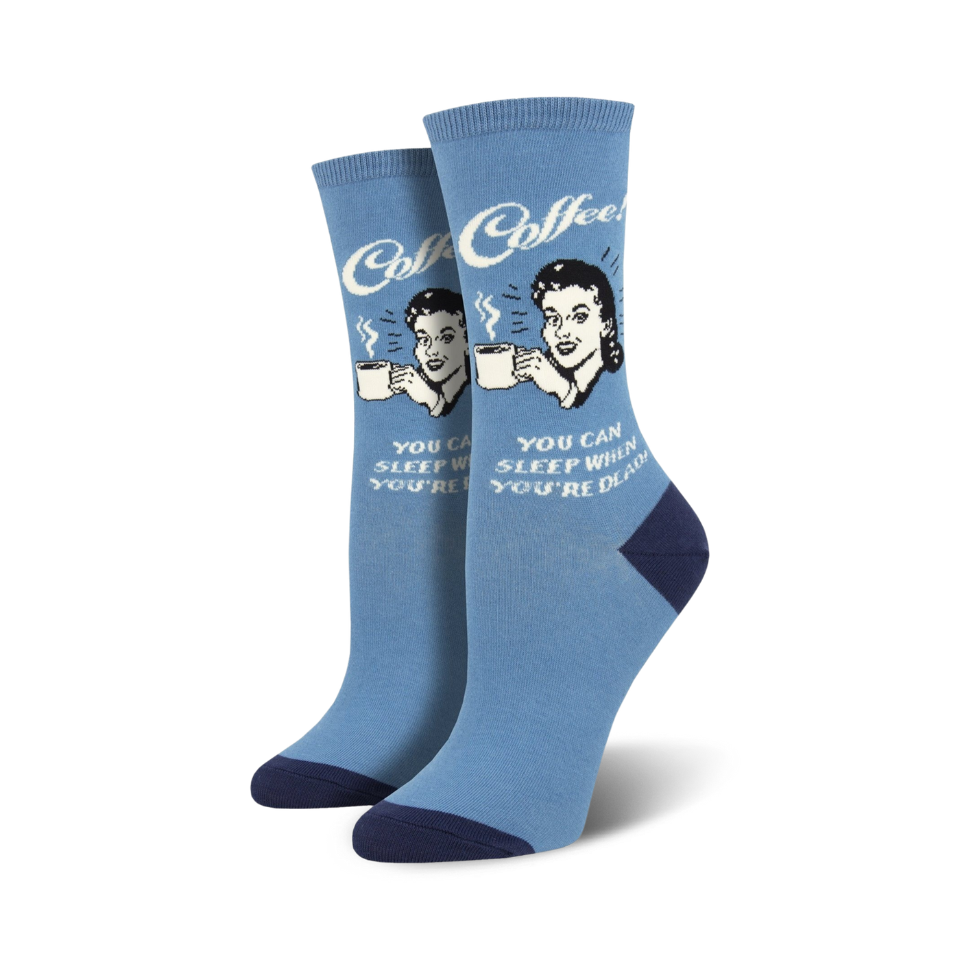 A pair of women's crew socks in light blue with a navy heel and toe. The socks feature a retro illustration of a woman drinking coffee and the text 'Sleep When You're Dead'.
