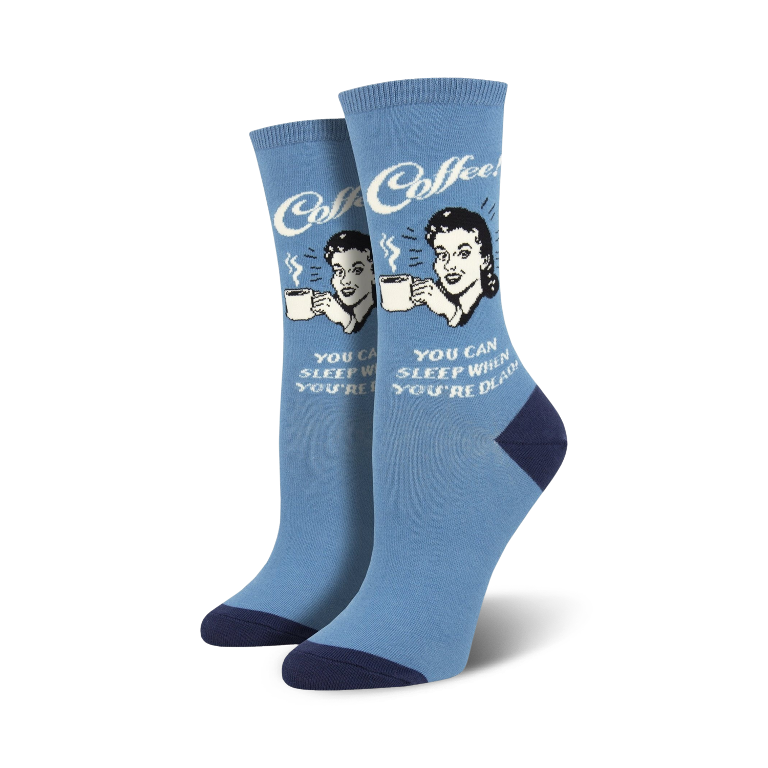 A pair of women's crew socks in light blue with a navy heel and toe. The socks feature a retro illustration of a woman drinking coffee and the text 'Sleep When You're Dead'.
