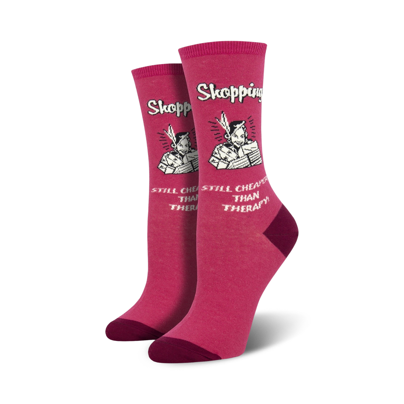 Pair of women's crew socks in pink featuring a retro-style illustration of a woman shopping with the text 'Shopping Still Cheaper Than Therapy'.