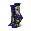 Women's crew socks in navy blue, featuring a colorful sugar skull with a crown, gold crowns, and floral details. Corona Extra logo is visible.