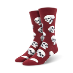 Pair of crimson red crew socks featuring a repeating pattern of white skulls.  A fun and slightly spooky design.