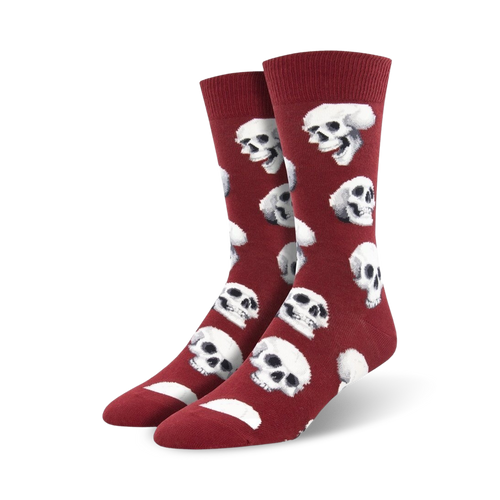 Pair of crimson red crew socks featuring a repeating pattern of white skulls.  A fun and slightly spooky design.