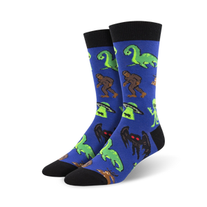 blue crew socks with a pattern of various fantasy cryptids like bigfoot, loch ness monster, and mothman.   