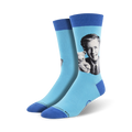 A pair of light blue crew socks with a portrait of Mister Rogers holding a teddy bear. The socks have a navy blue cuff.