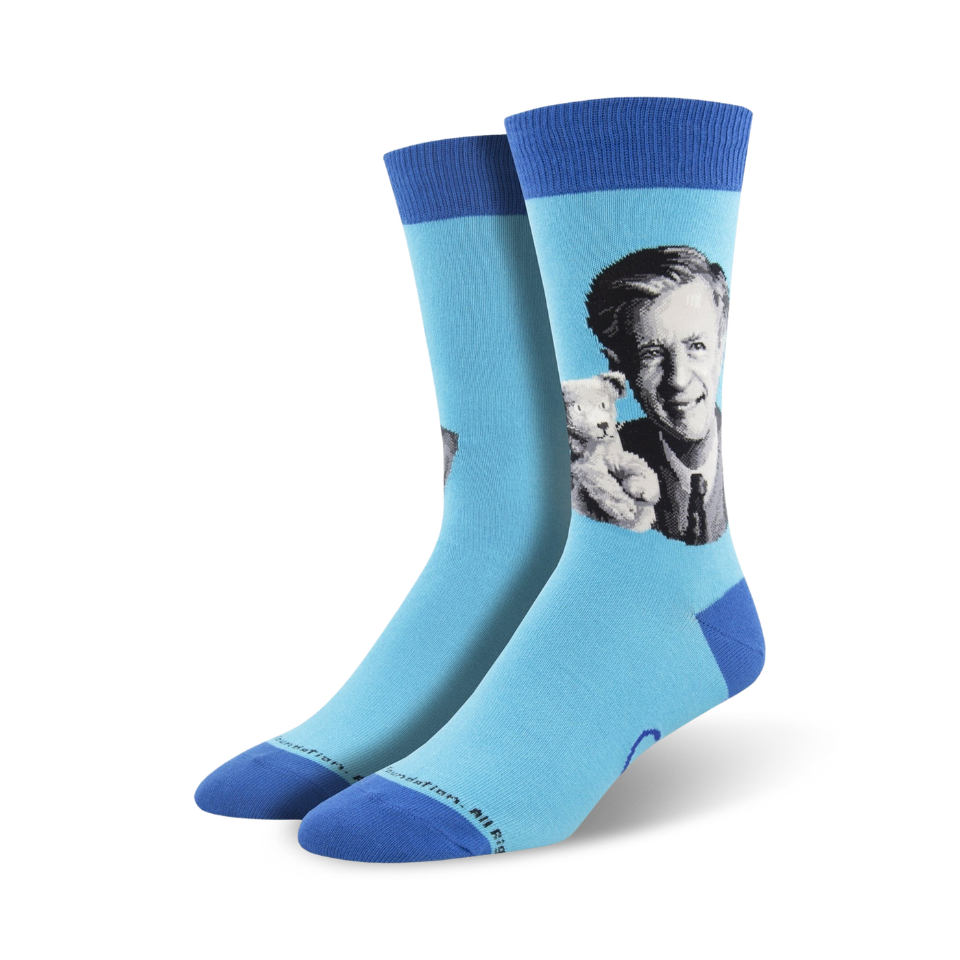 A pair of light blue crew socks with a portrait of Mister Rogers holding a teddy bear. The socks have a navy blue cuff.