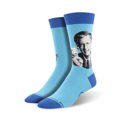 blue mister rogers portrait crew socks for men feature the beloved host in a black suit coat, light dress shirt, and dark tie. he holds a stuffed tiger.  