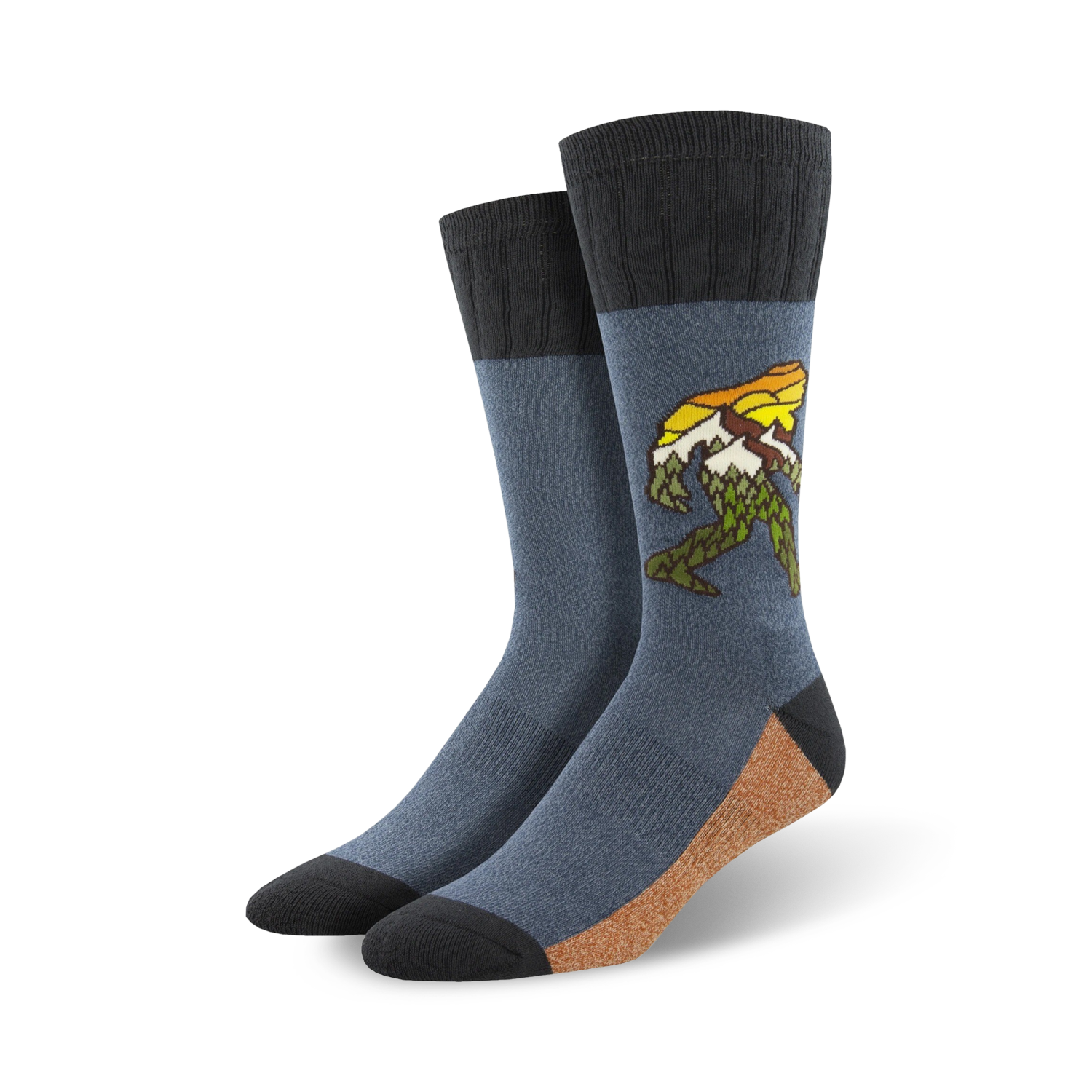 A pair of men's crew socks in blue and tan, featuring a graphic of Bigfoot walking through a mountain range.  The design includes yellow and green accents.